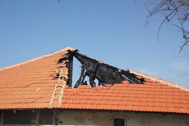 Picture of damaged roof with large area of tiles missing