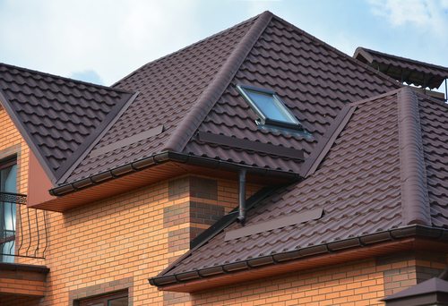 Beautiful new brown roof tiles on brand new home with three separate angled roofs
